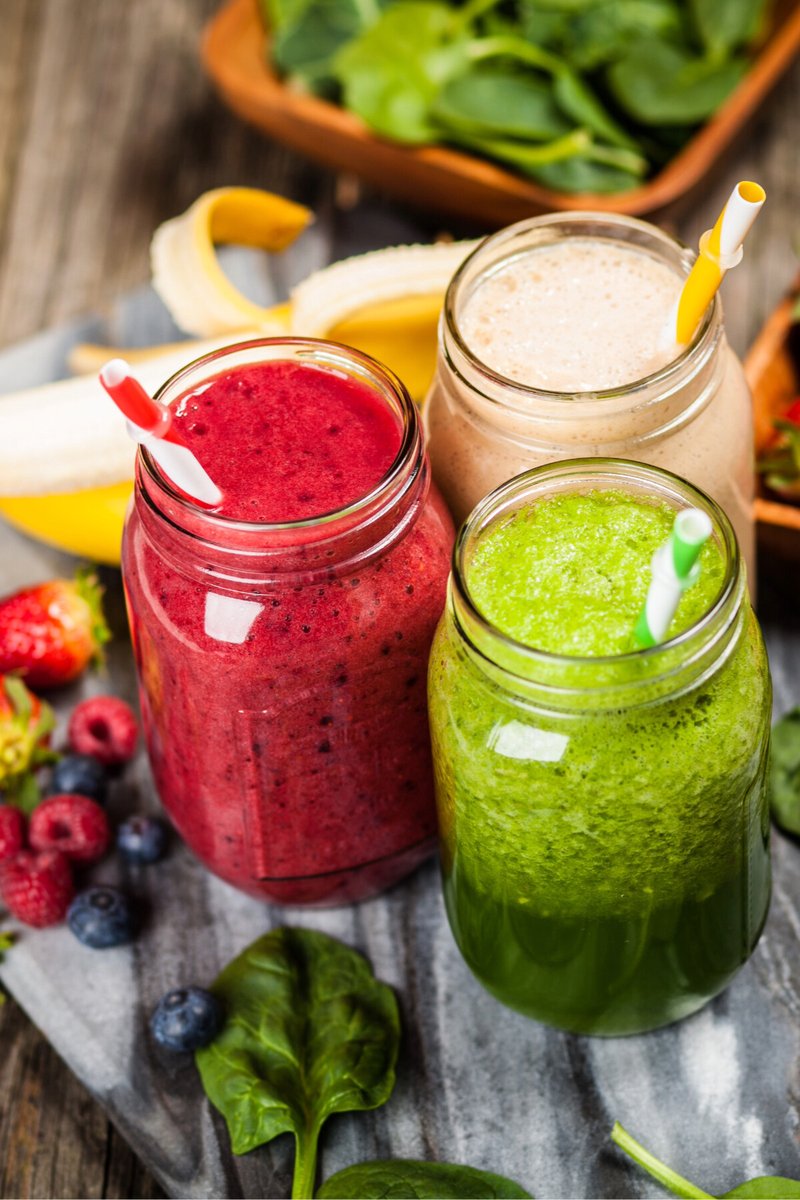 hree colorful summer smoothies made with fresh berries, banana, spinach, and seasonal fruit in mason jars for a healthy and refreshing drink.