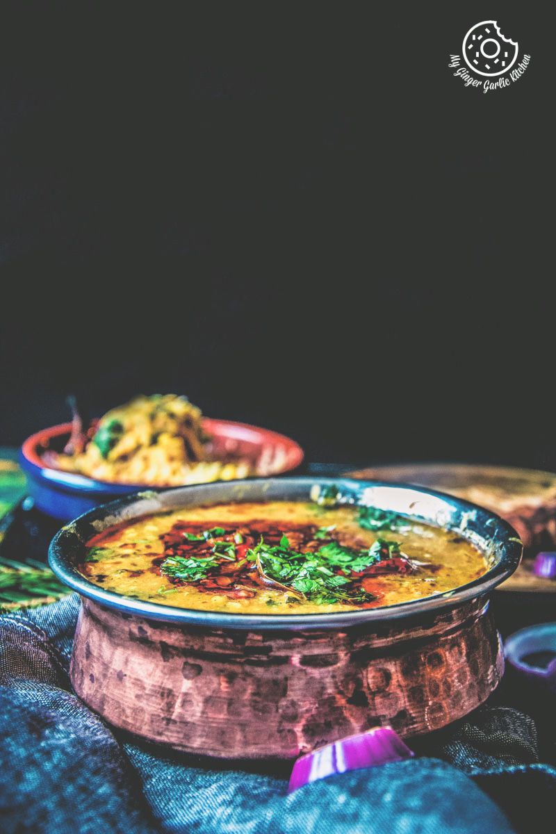 a bowl of restaurant style dal tadka topped with tempering and fresh cilantro 