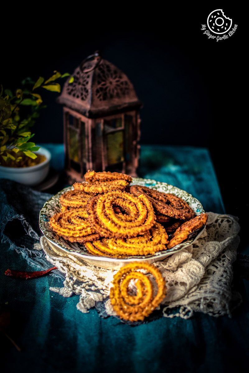 a plate of rice chakli on a table with a lantern
