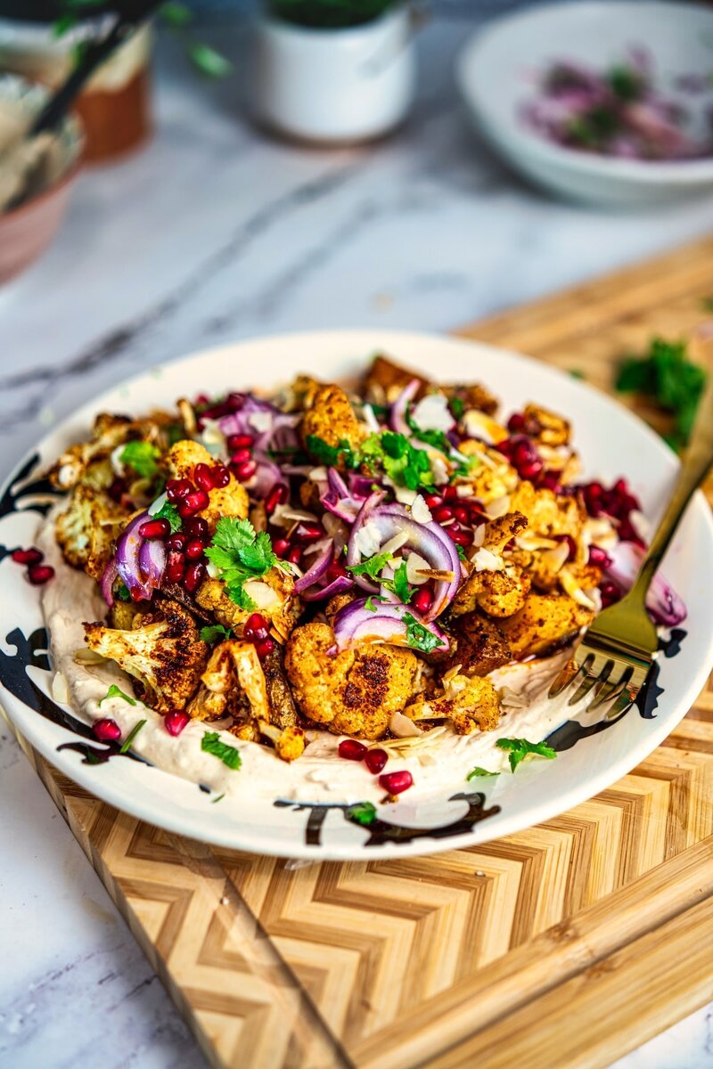 Roasted Cauliflower Tahini Bowl served over creamy tahini yogurt with golden roasted cauliflower and Mediterranean-style toppings