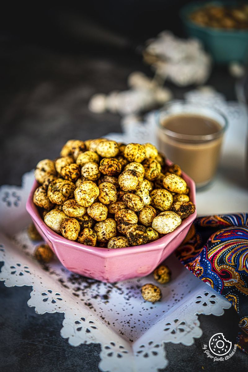 healthy snack roasted makhana in a pink bowl with four makhanas in a tray