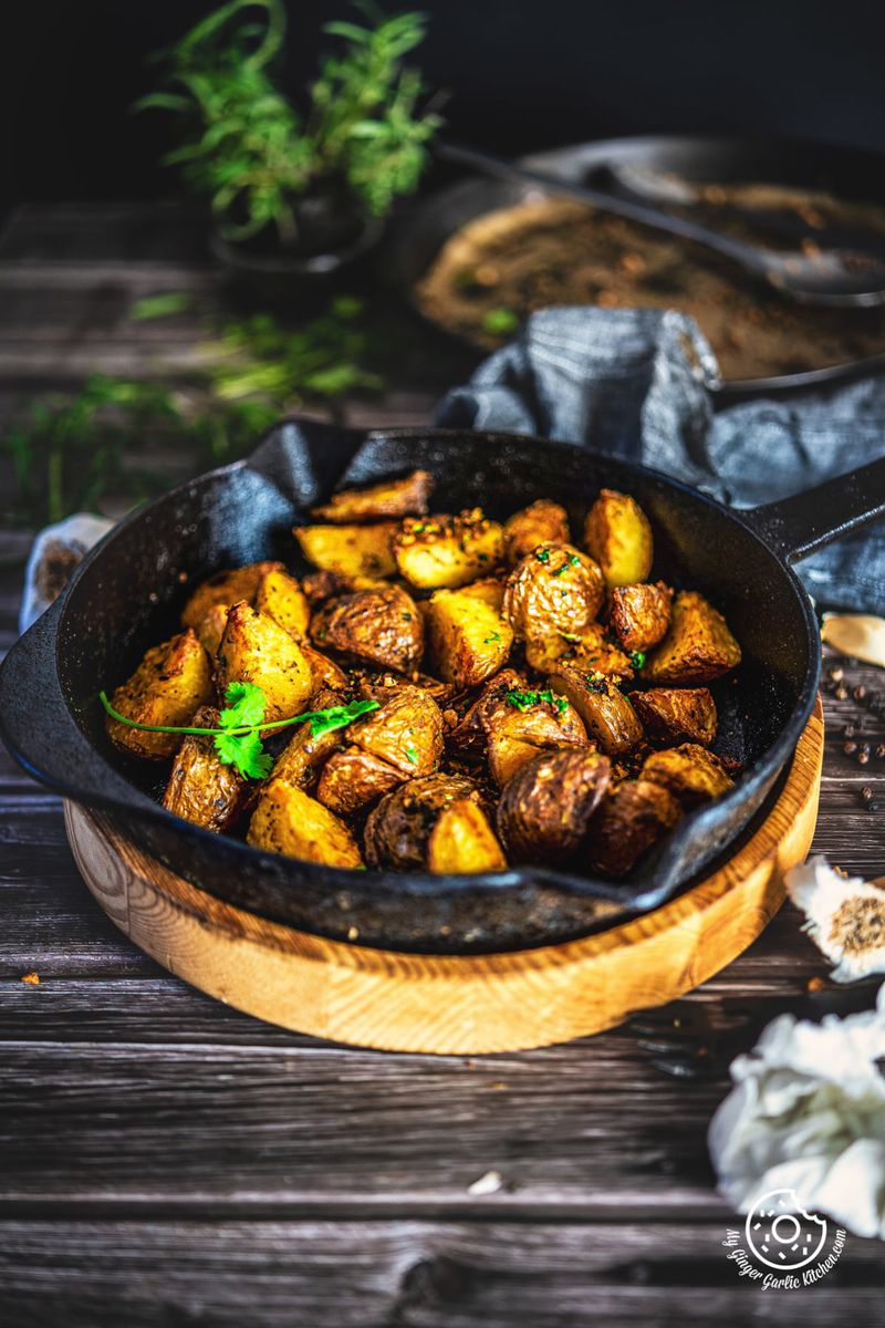roasted potatoes garnished with cilantro in a cast iron pan