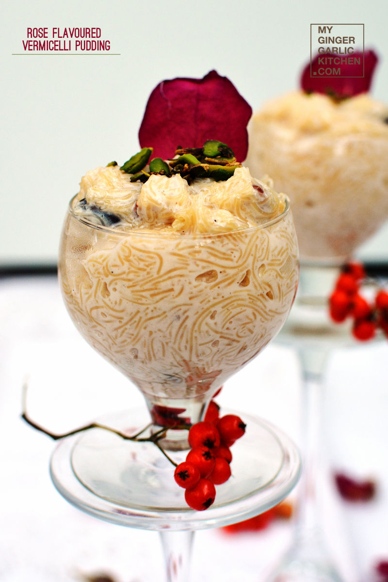 two glasses of rose flavoured vermicelli pudding with pistachios in them