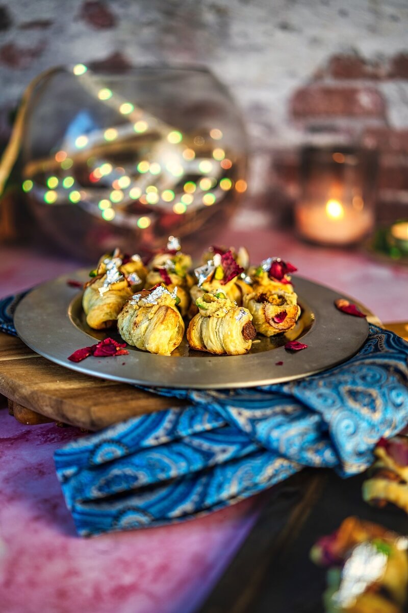 Royal Burfi Date Puff Bites displayed on a festive table with lights in background easy Indian fusion dessert recipe