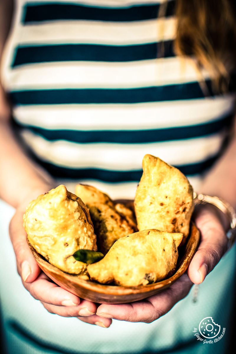 a girl holding a samosa bowl