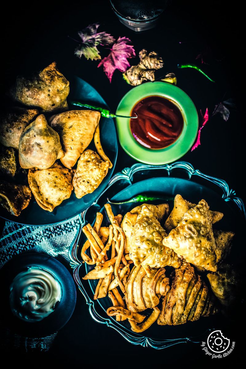 overhead shot of samosa plates and bowl of a ketchup on sides