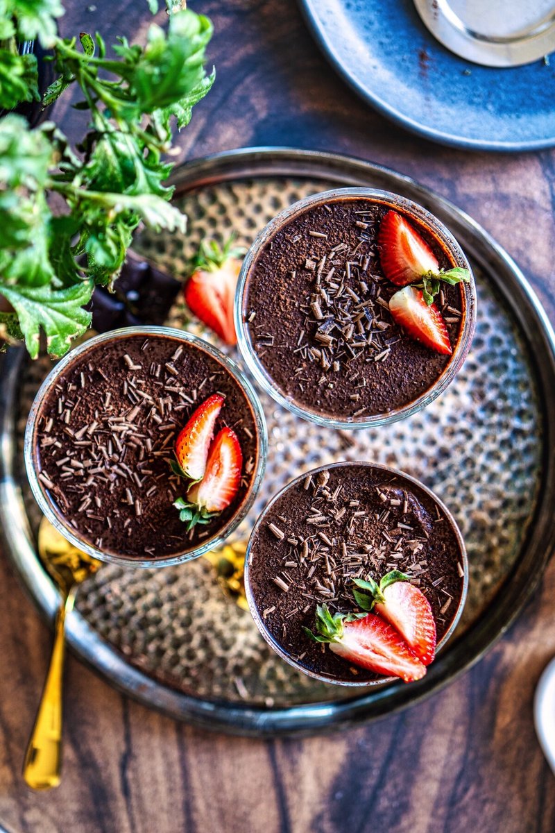 Silken tofu chocolate pudding served in glass dessert cups with strawberries and shaved dark chocolate
