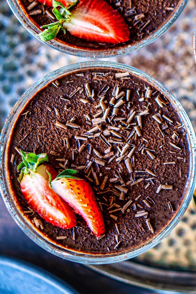 Close-up of thick silken tofu chocolate pudding with fresh strawberries and dark chocolate shavings