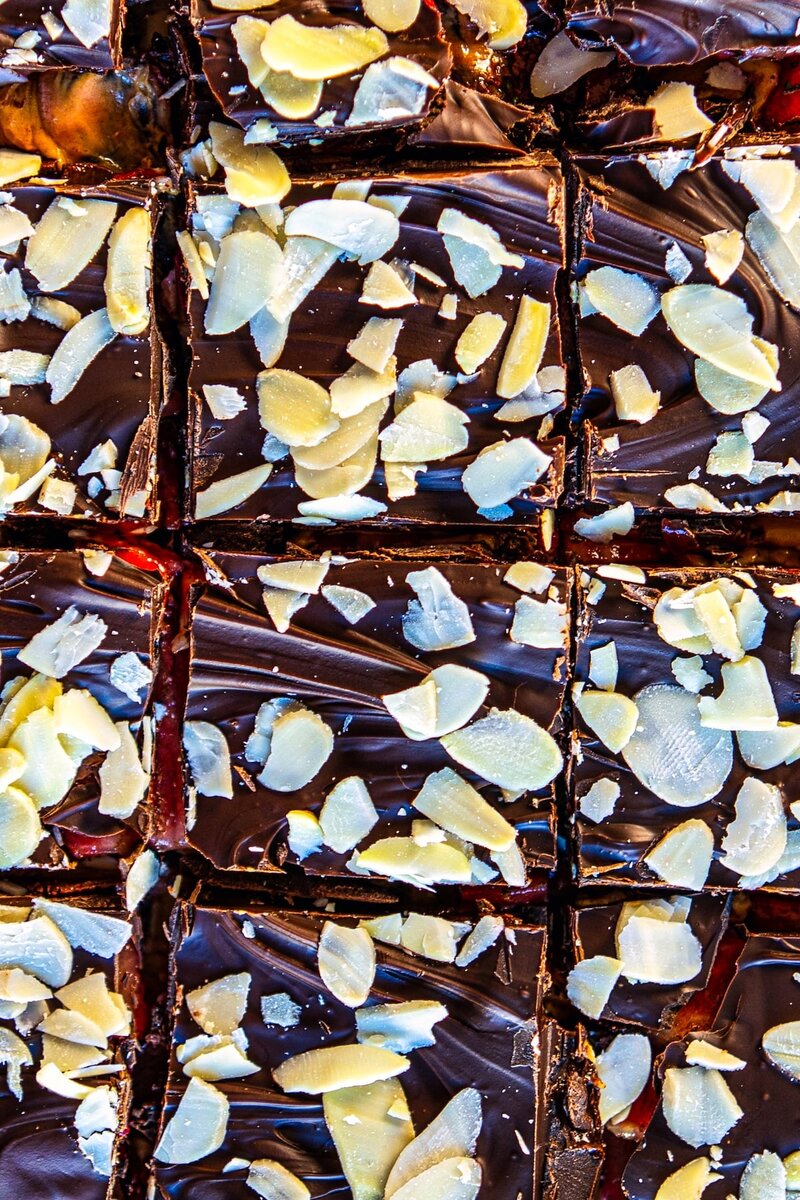 Close-up of chocolate date bark with strawberries and almond flakes showing rich chocolate texture