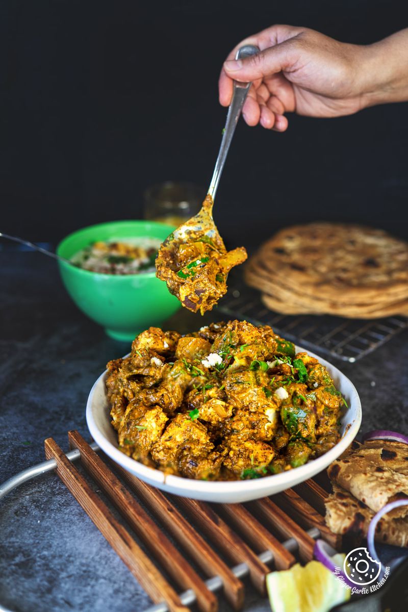 photo of a person holding a spoon full of tawa paneer over a plate