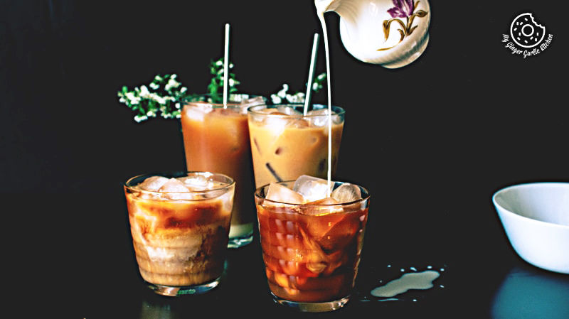 three glasses of thai iced tea drink with ice and a pitcher
