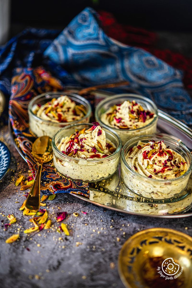 4 thandai shrikhand transparent bowls kept on an oval metal tray