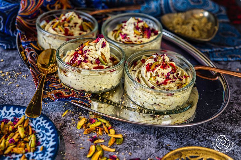 thandai shrikhand bowls topped with rose syrup, pistachios, and dried rose petals