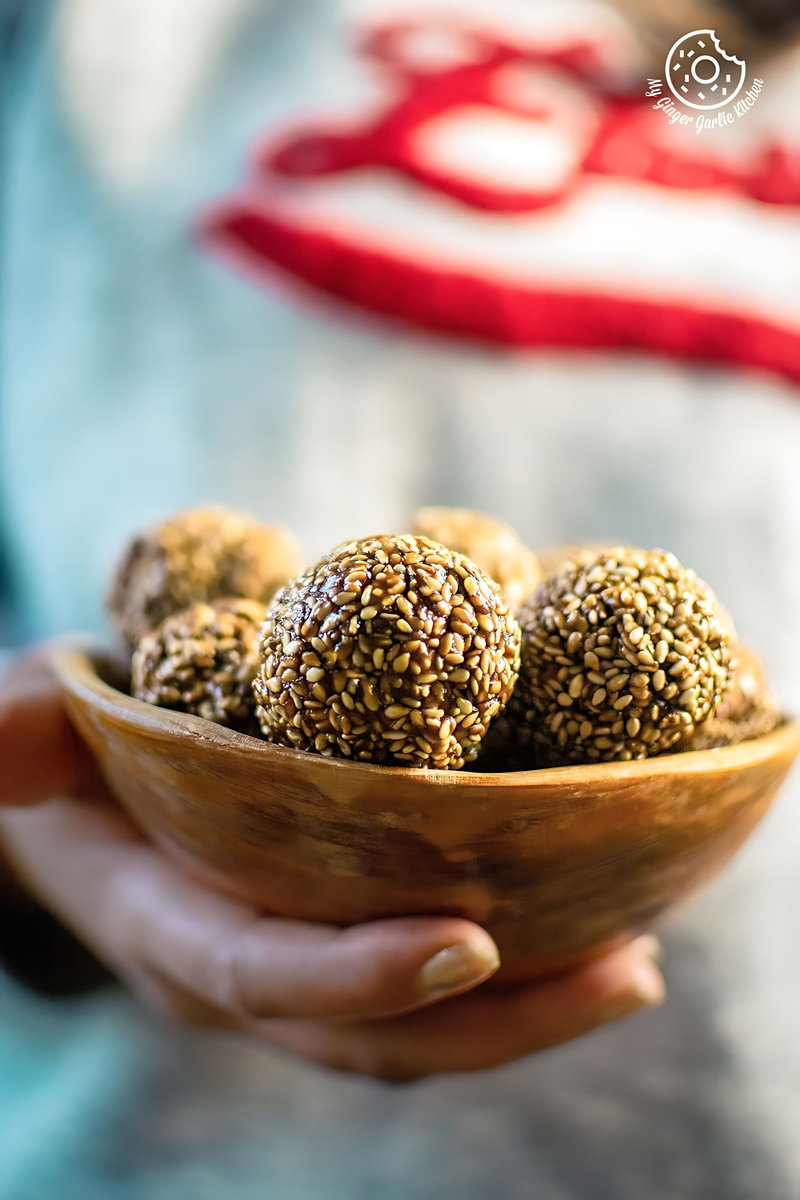 a person holding a til laddu bowl