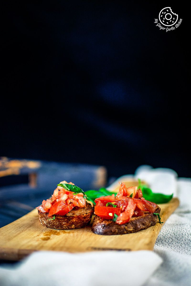 overhead shot of tomato bruschetta served in a white oval shaped plate