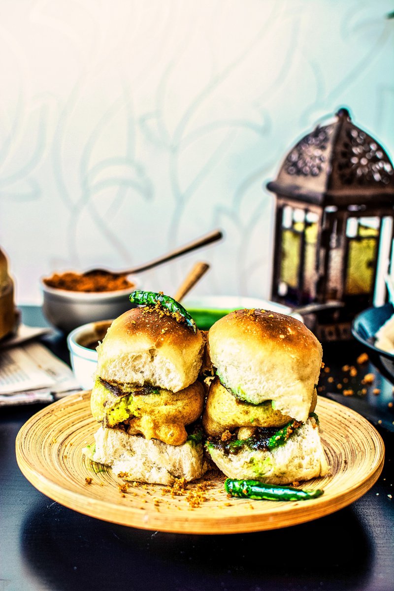 A plate of two vada pav, a popular Indian street food made with a potato patty and a bun.