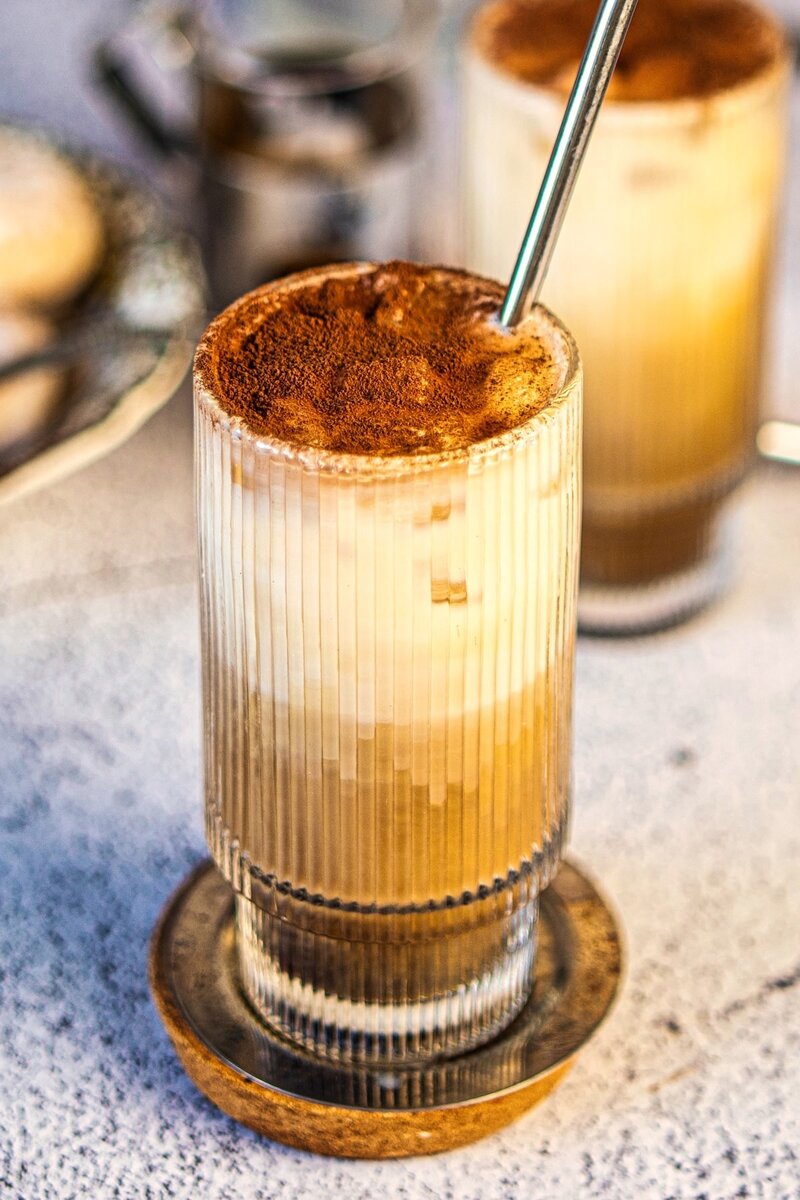 Close-up vanilla iced latte with layered milk and espresso, café-style iced coffee with frothy finish