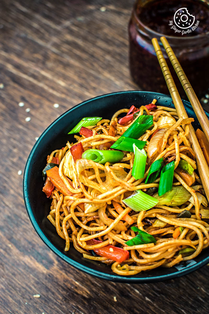 asian veg schezwan noodles with vegetables and vegetables in a bowl with chopsticks