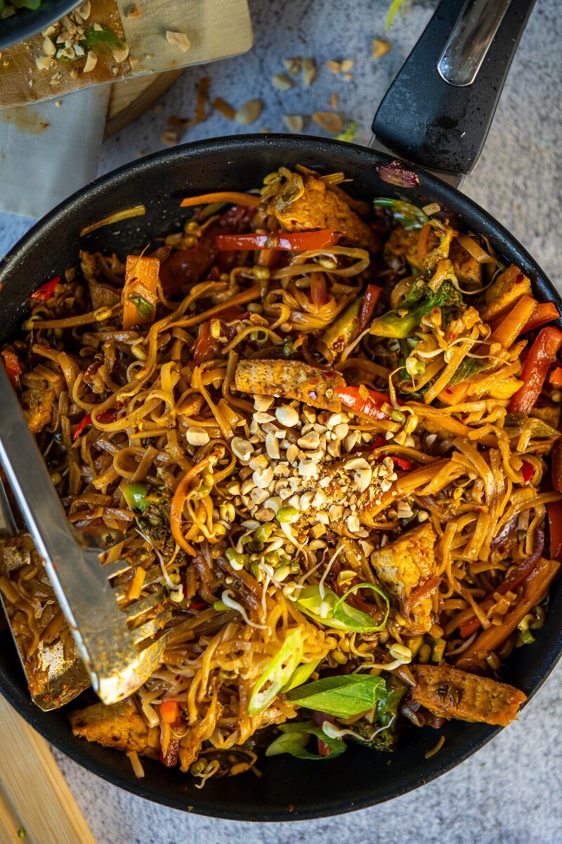Authentic vegan Pad Thai in a pan topped with crushed peanuts and green onions, quick and easy gluten free Thai stir fry.