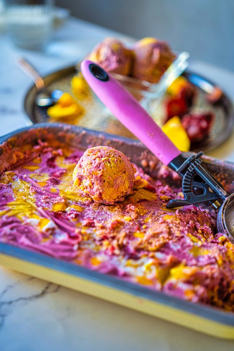 Close-up of creamy Vegan Strawberry Mango Ice Cream with beautiful strawberry and mango swirls in a loaf pan