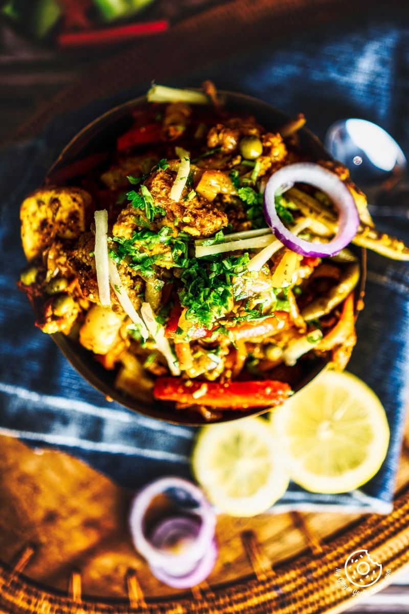 overhead closeup shot of vegetable jalfrezi served in a brass bowl