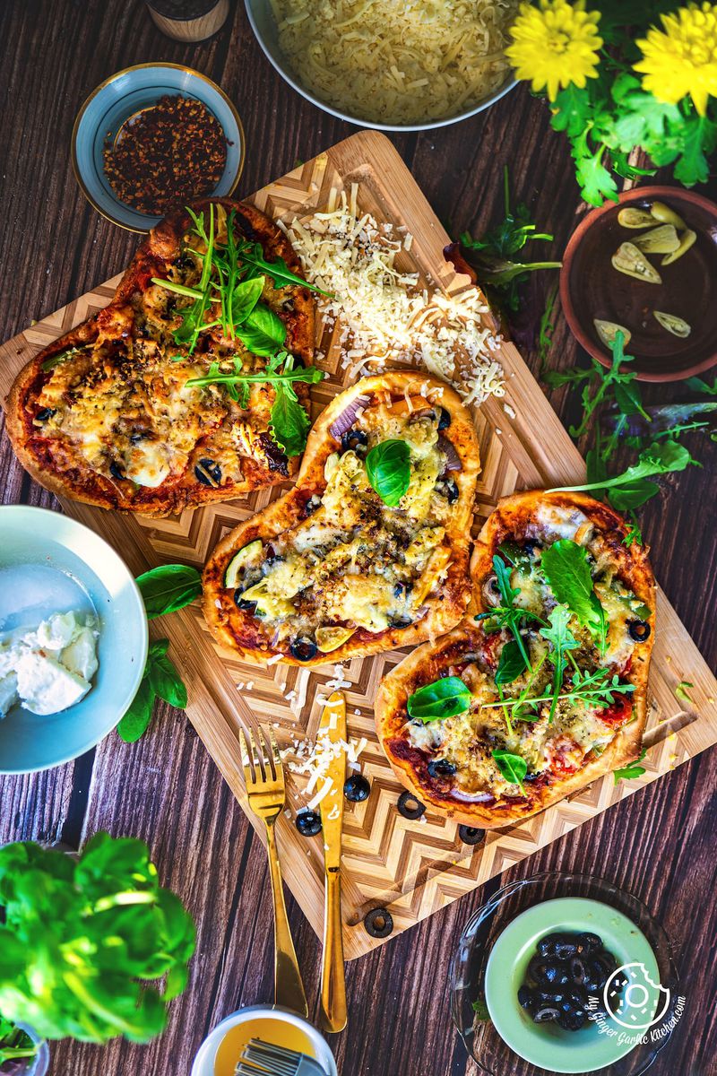 overhead shot of 3 vegetarian heart pizza sitting on top of a wooden table