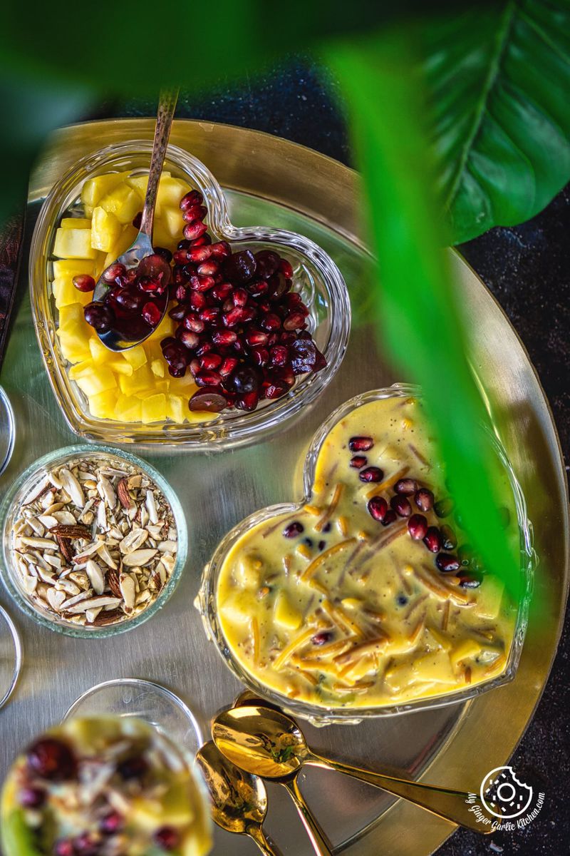 overhead shot of vermicelli fruit custard bowl in a golden plate along with a fruit plate
