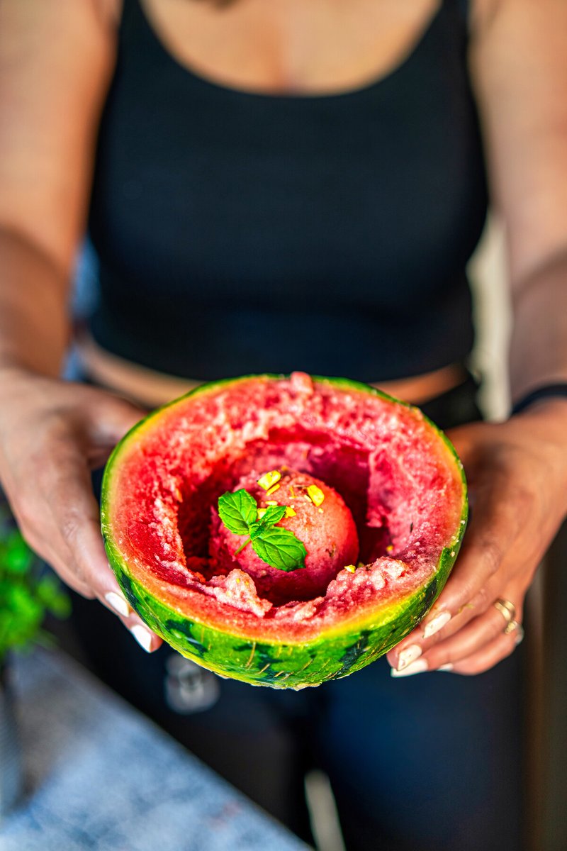 Viral Watermelon Ice Cream served inside a frozen mini watermelon shell with fresh mint and chopped pistachios