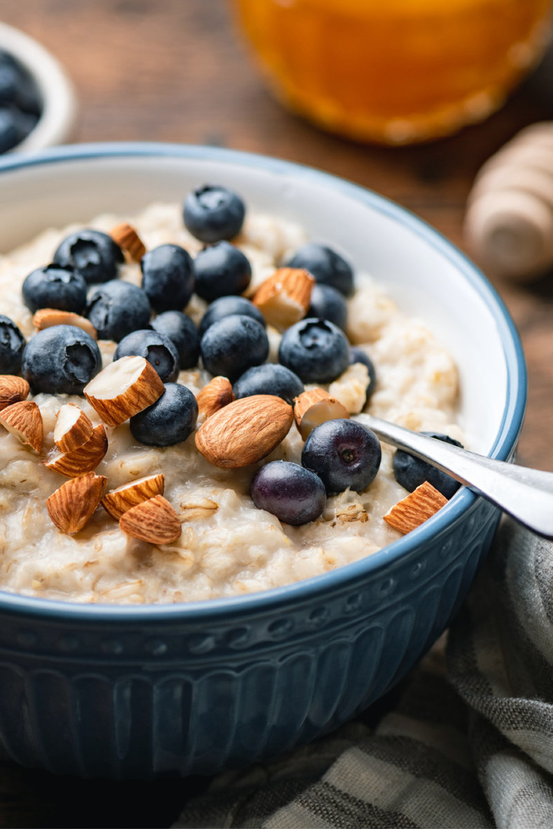 bowl of oatmeal with blueberries and almonds on a table
