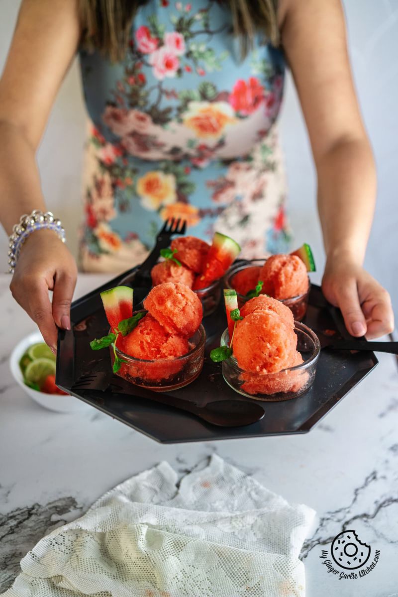a female holding watermelon sorbet bowls tray