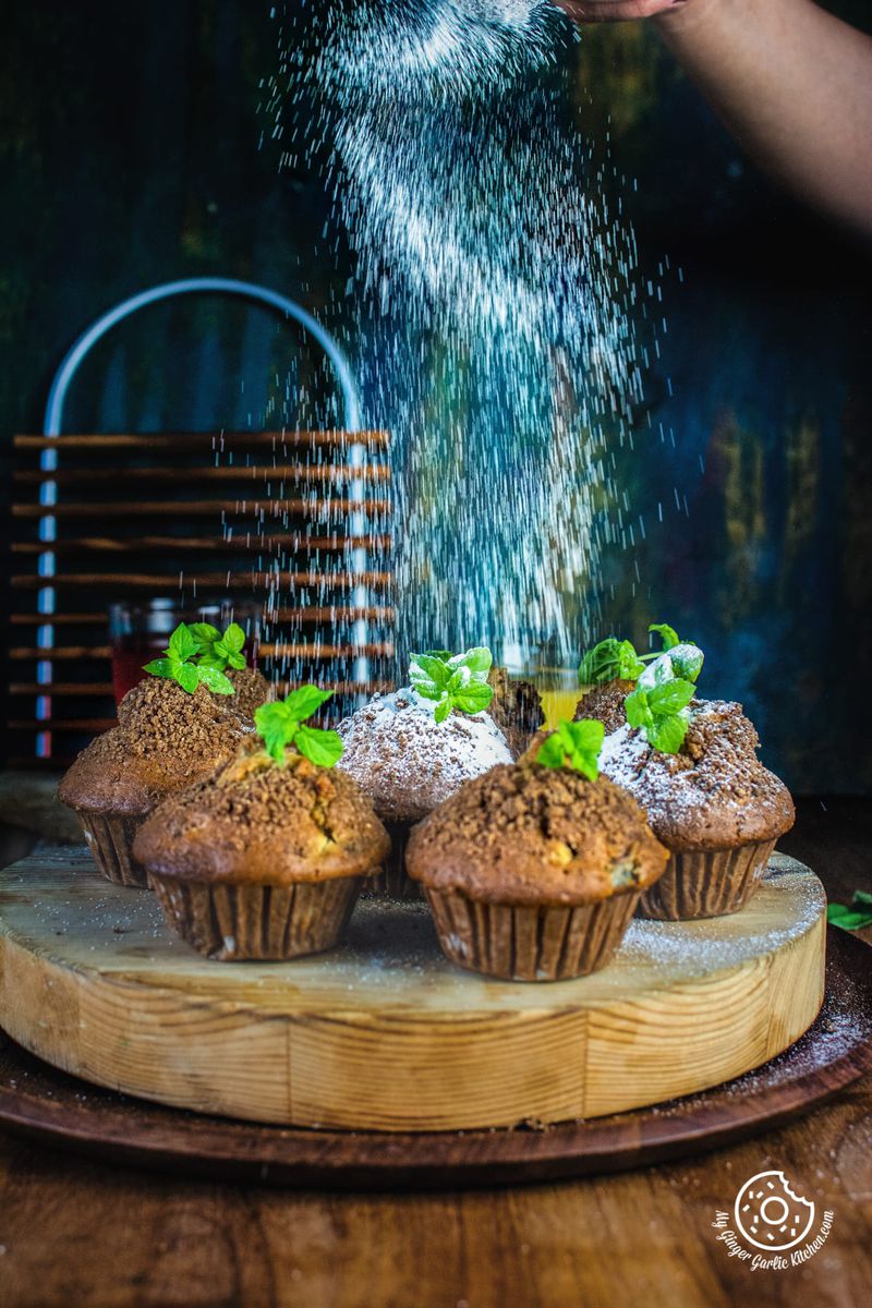sugar sprinkling on whole wheat peach muffins topped with mint leaves
